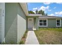 Inviting front entrance featuring a white door, textured walls and a concrete walkway at 176 Pine Crse, Ocala, FL 34472