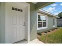Close-up of a front door with glass accents and clean, manicured landscaping at 176 Pine Crse, Ocala, FL 34472