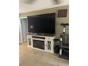 Cozy living room with an electric fireplace, large TV and decorative shelving at 3800 Ne 24Th Ct, Ocala, FL 34479
