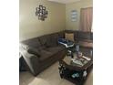 Comfortable living room featuring a large brown couch, tile floors, and decor at 3800 Ne 24Th Ct, Ocala, FL 34479