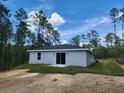The backyard features a gray exterior with sliding glass doors, offering a private outdoor space at 404 Nw Redwing Rd, Dunnellon, FL 34431