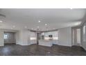 A spacious living room featuring wood flooring and an open layout to the kitchen area at 5830 Sw 121St Ter, Ocala, FL 34481