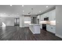Open-concept living room with kitchen, featuring sleek wood floors and recessed lighting at 5830 Sw 121St Ter, Ocala, FL 34481