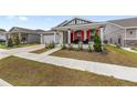 Attractive residence featuring a two-car garage, red shutters, covered porch, and green lawn at 6486 Sw 75Th Avenue Rd, Ocala, FL 34474
