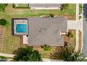 Aerial view showcasing a private screened-in pool, a well-maintained roof, and manicured landscaping at 6984 Sw 94Th Ct, Ocala, FL 34481