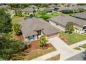 An aerial view shows a well-maintained home with a two-car garage and long driveway, surrounded by lush greenery at 6984 Sw 94Th Ct, Ocala, FL 34481