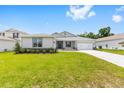 Well-maintained single-story home with a bright green lawn, stone accents, and a two-car garage at 7638 Sw 60Th St, Ocala, FL 34474