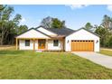 Charming single-story home featuring a manicured lawn, brown garage door, and welcoming covered porch at 8200 Sw 125Th Court Rd, Dunnellon, FL 34432