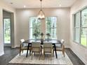 Bright dining room with a modern chandelier, large windows, and stylish decor at 8290 Nw 17Th Cir, Ocala, FL 34475