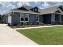 A charming blue house with a well-maintained lawn and landscaping, featuring a two-car garage at 8290 Nw 17Th Cir, Ocala, FL 34475