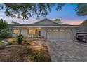 Charming single-story home with a brick facade, covered porch, and beautifully landscaped front yard at twilight at 8998 Sw 94Th St # D, Ocala, FL 34481