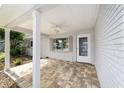 Charming covered brick patio with ceiling fan and view of the landscaped front yard at 8998 Sw 94Th St # D, Ocala, FL 34481