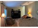 Inviting living room with comfortable seating, ceiling fan, and ample natural light at 9131 Se 135Th St, Summerfield, FL 34491
