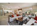 Open-concept living room boasts an airy feel with hardwood floors and seamless flow to other living spaces at 9459 Se 124Th Loop, Summerfield, FL 34491