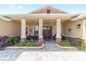 Inviting front porch with stone pillars and beautiful landscaping offering a relaxing outdoor seating area at 9607 Sw 79Th Lane Rd, Ocala, FL 34481