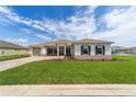 Traditional single-Gathering home with manicured lawn, gray trim, and welcoming two-car driveway at 10553 Sw 98Th Pl, Ocala, FL 34481