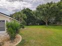 Expansive backyard featuring a lush lawn, mature trees, and garden beds, offering a serene outdoor space at 13863 Se 85Th Cir, Summerfield, FL 34491