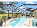 Screened in pool area with outdoor seating and a picturesque golf course view at 15119 Sw 14Th Avenue Rd, Ocala, FL 34473