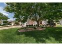 Landscaped front yard featuring mature shade trees, green grass, and neatly trimmed shrubbery at 1748 Sw 157Th Place Rd, Ocala, FL 34473