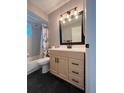 Well-lit bathroom featuring a modern vanity, stylish light fixture, and a shower-tub combination with a curtain at 21 Pecan Course Cir, Ocala, FL 34472