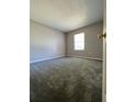 Cozy bedroom with neutral walls, plush carpeting, a window for natural light, and a glimpse of the door at 21 Pecan Course Cir, Ocala, FL 34472