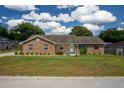 Single-story brick home with manicured landscaping, healthy green lawn, and a cloudy sky at 3295 Se 56 Ave, Ocala, FL 34480