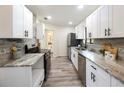 Modern kitchen featuring stainless steel appliances, granite countertops, and white cabinetry at 346 Emerald Rd, Ocala, FL 34472