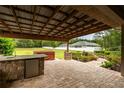 Spacious covered patio featuring a full outdoor kitchen, hot tub, and landscaped backyard views at 4015 Se 22Nd St, Ocala, FL 34471