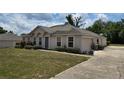 A view of a single story home showing the garage, landscaping, and driveway with a blue entry door at 4460 Sw 44Th St, Ocala, FL 34474