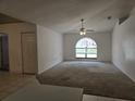 Spacious living room featuring a ceiling fan, carpeted floors, arched window, and natural light at 4460 Sw 44Th St, Ocala, FL 34474