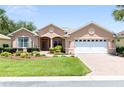 Beautiful single-story home boasts lush lawn, complemented by manicured landscaping and brick-paved driveway at 8303 Sw 82Nd Cir, Ocala, FL 34481