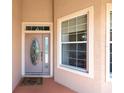 Close-up of front door showcasing decorative glass, sidelights, and a welcoming entrance mat at 8303 Sw 82Nd Cir, Ocala, FL 34481