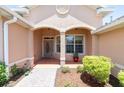 Inviting front porch with decorative columns, a stylish front door, and well-maintained landscaping at 8303 Sw 82Nd Cir, Ocala, FL 34481