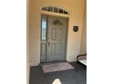 Elegant front door with decorative glass, sidelight, and transom window, enhanced by a stylish welcome mat at 8447 Sw 82Nd Loop, Ocala, FL 34481