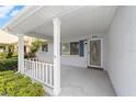 Inviting covered porch with white railing, providing a cozy outdoor seating area at 8885 Sw 90Th Ave, Ocala, FL 34481