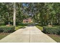 Long driveway leading to a stately brick home with well-manicured landscaping and mature trees at 9175 Se 7Th Avenue Rd, Ocala, FL 34480