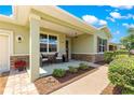 Inviting front porch with seating, stone accents, and a view of the meticulously maintained landscaping at 9203 Sw 97Th Cir, Ocala, FL 34481