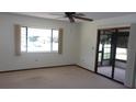 Neutral living room showcasing carpet flooring, a ceiling fan, and access to the lanai at 9960 Sw 103Rd Ln, Ocala, FL 34481