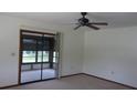 Bright living room featuring carpet flooring, a ceiling fan, and a screened-in lanai at 9960 Sw 103Rd Ln, Ocala, FL 34481