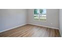 Cozy bedroom with wood-look floors, a large window, and neutral paint at 10207 Sw 41St W Ter, Ocala, FL 34476