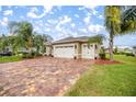 View of the home showing the three car garage and decorative landscaping at 10279 Julia Isles Ave, Oxford, FL 34484