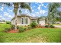 Well maintained home with lush landscaping and mature palm trees at 10279 Julia Isles Ave, Oxford, FL 34484