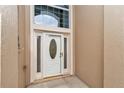 Home's bright white front door with leaded glass window flanked by sidelights and transom window at 11062 Sw 73Rd Ct, Ocala, FL 34476