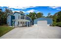 Charming blue two-story home with a metal roof, carport, detached garage, and green lawn at 12690 Ne Highway 315, Fort Mc Coy, FL 32134