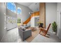 Bright living room with high ceilings, brick fireplace, and a wooden staircase at 12690 Ne Highway 315, Fort Mc Coy, FL 32134