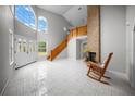 Bright open living room with a brick fireplace, wooden staircase, and large windows at 12690 Ne Highway 315, Fort Mc Coy, FL 32134