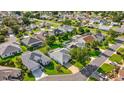An aerial view of a well-landscaped home, surrounded by lush greenery and other houses at 1308 La Estrellita Way, The Villages, FL 32162