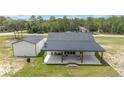 Backyard view of this home featuring a large patio and a detached garage at 13663 Sw 66Th St, Ocala, FL 34481