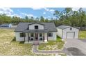 Beautiful home with inviting front porch, rocking chairs, and detached garage at 13663 Sw 66Th St, Ocala, FL 34481