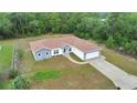 Aerial view showcasing the single-story home featuring neutral gray paint, brown roof, an attached two-car garage, and long driveway at 14550 Sw 61St Ct, Ocala, FL 34473